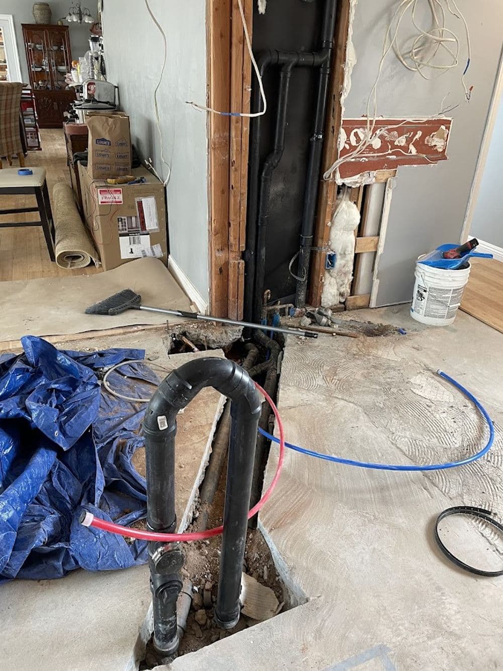 exposed pipes and plumbing in a home renovation with tools and materials nearby